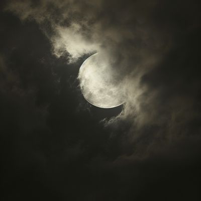 the moon is seen through the clouds in a dark sky