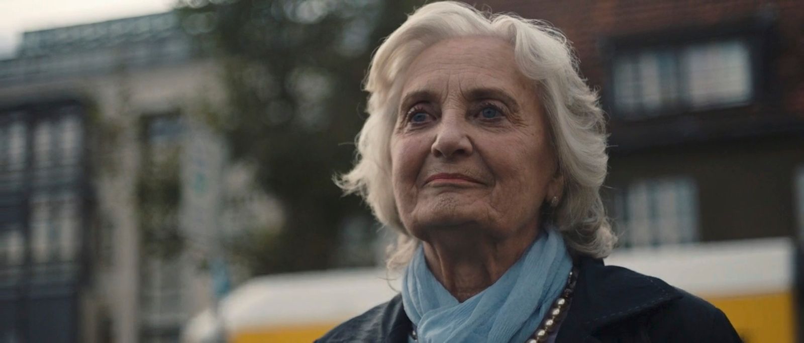 a woman in a black jacket and a blue scarf