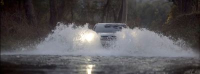 a white car driving through a flooded street