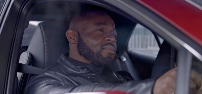 a man sitting in a car looking out the window