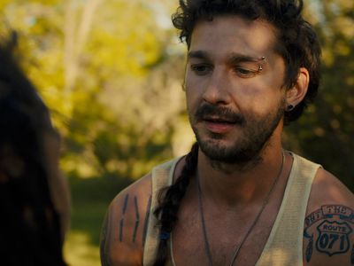 a man with tattoos on his chest and a woman with a braid