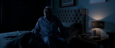 a man sitting on a bed in a dark room