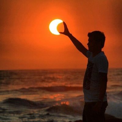 a man standing on a beach holding a frisbee