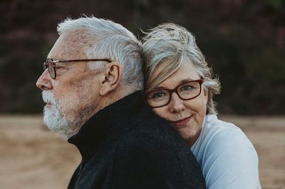 an older man and a younger woman embracing each other