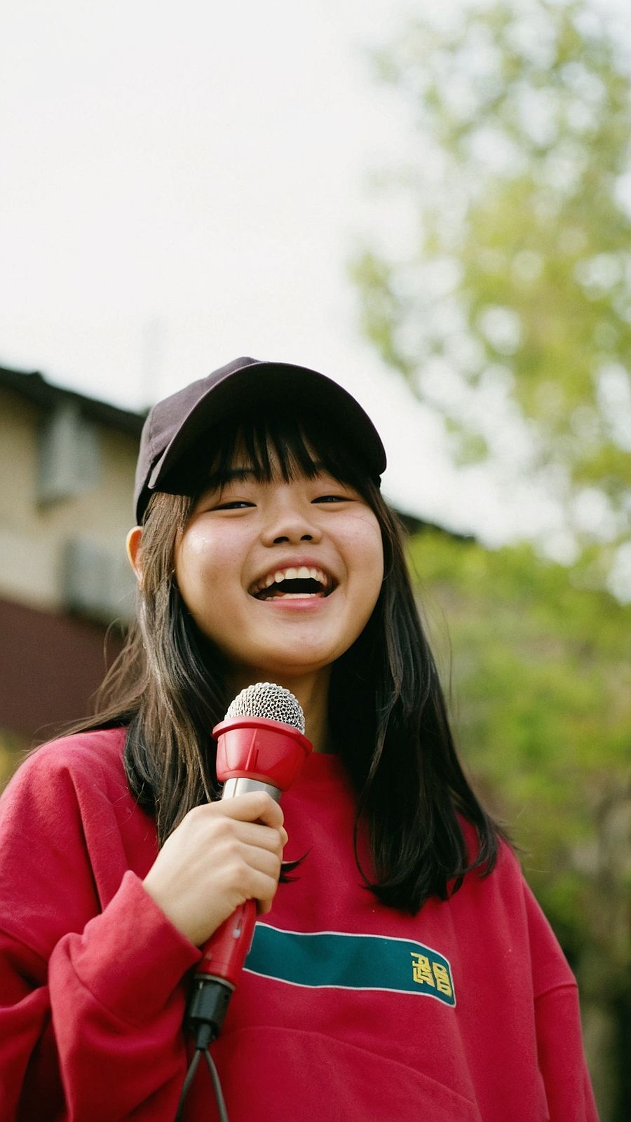 a woman holding a microphone and smiling at the camera