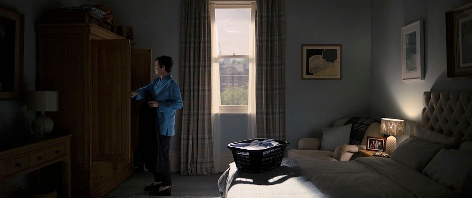 a woman standing in a bedroom next to a window