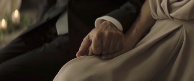 a close up of a person in a tuxedo holding another person's