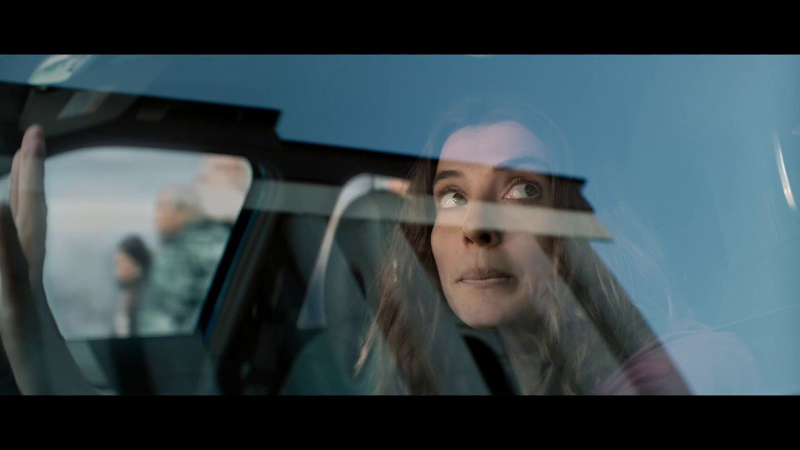 a woman sitting in a car looking out the window