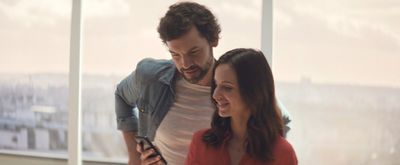 a man and a woman looking at a cell phone