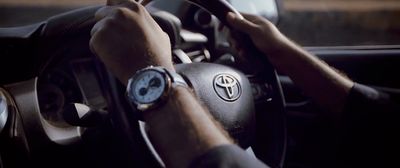 a man driving a car with his hands on the steering wheel