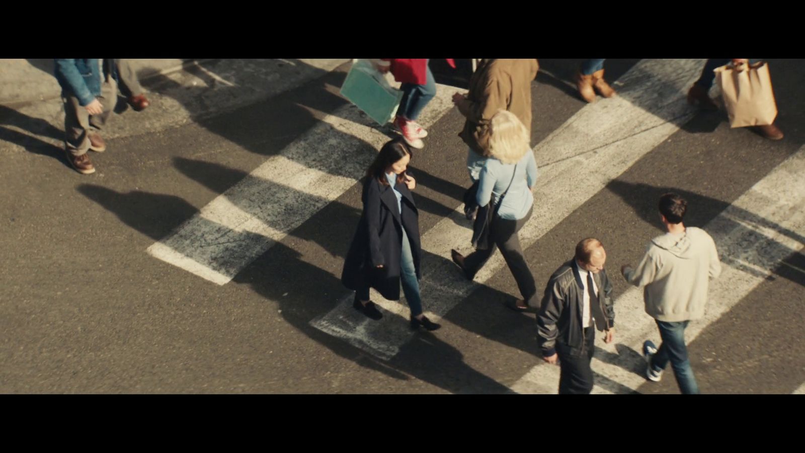 a group of people walking across a street