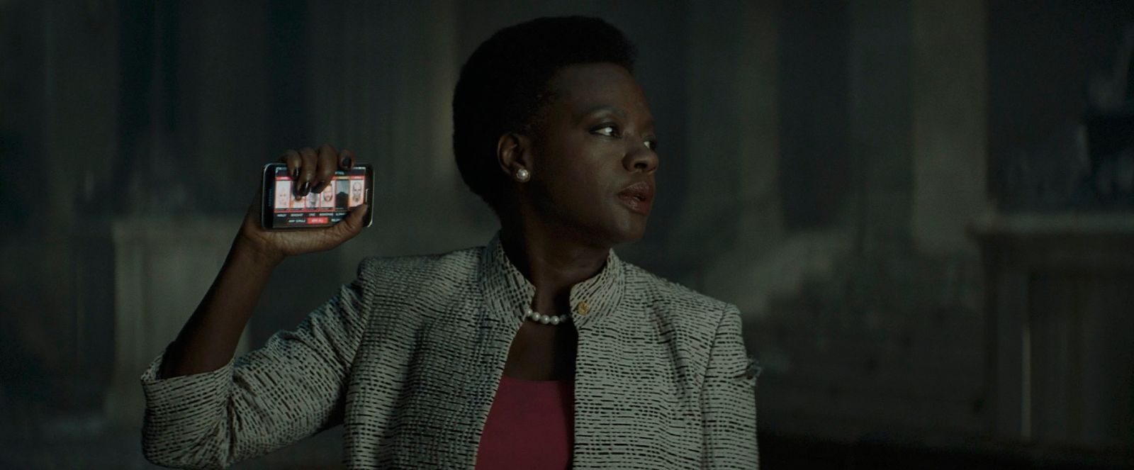 a woman holding up a cell phone in a dark room