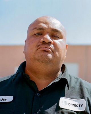 a man with a black shirt and a black and white name tag