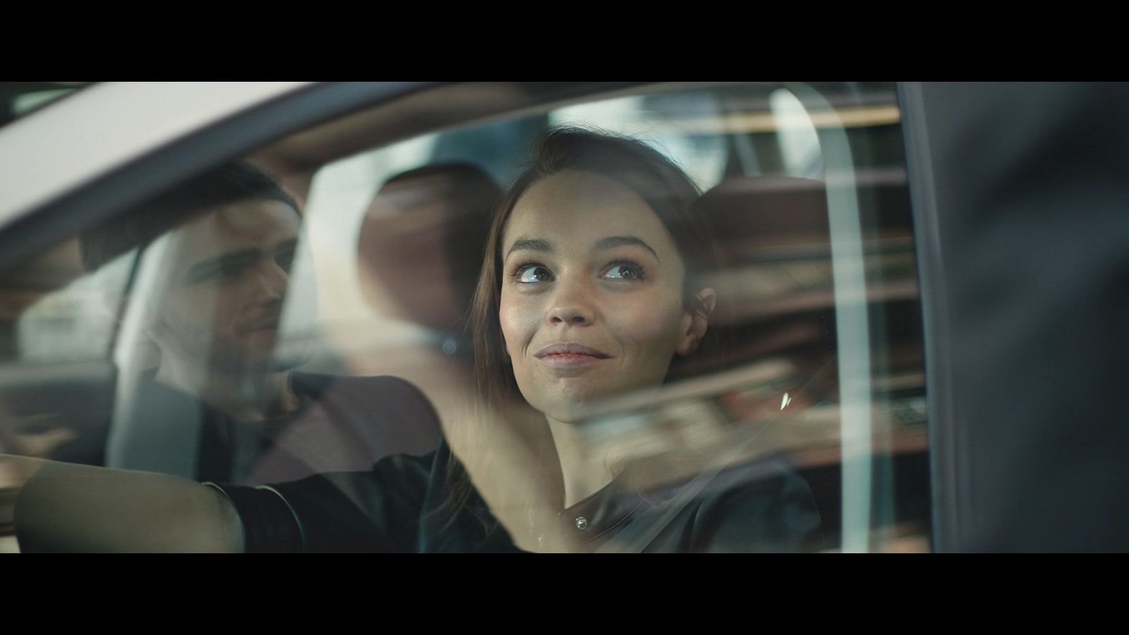 a woman sitting in a car looking out the window