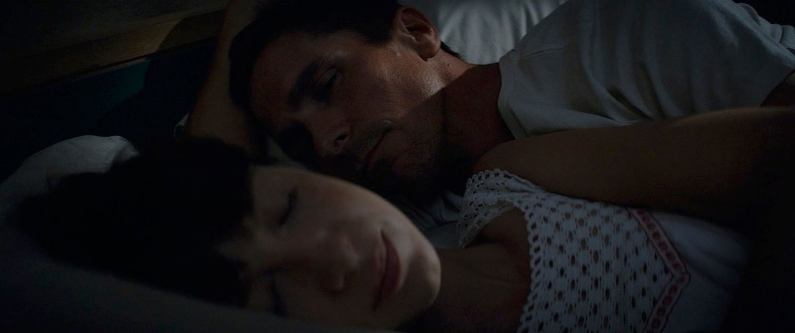 a man and a woman laying in bed together