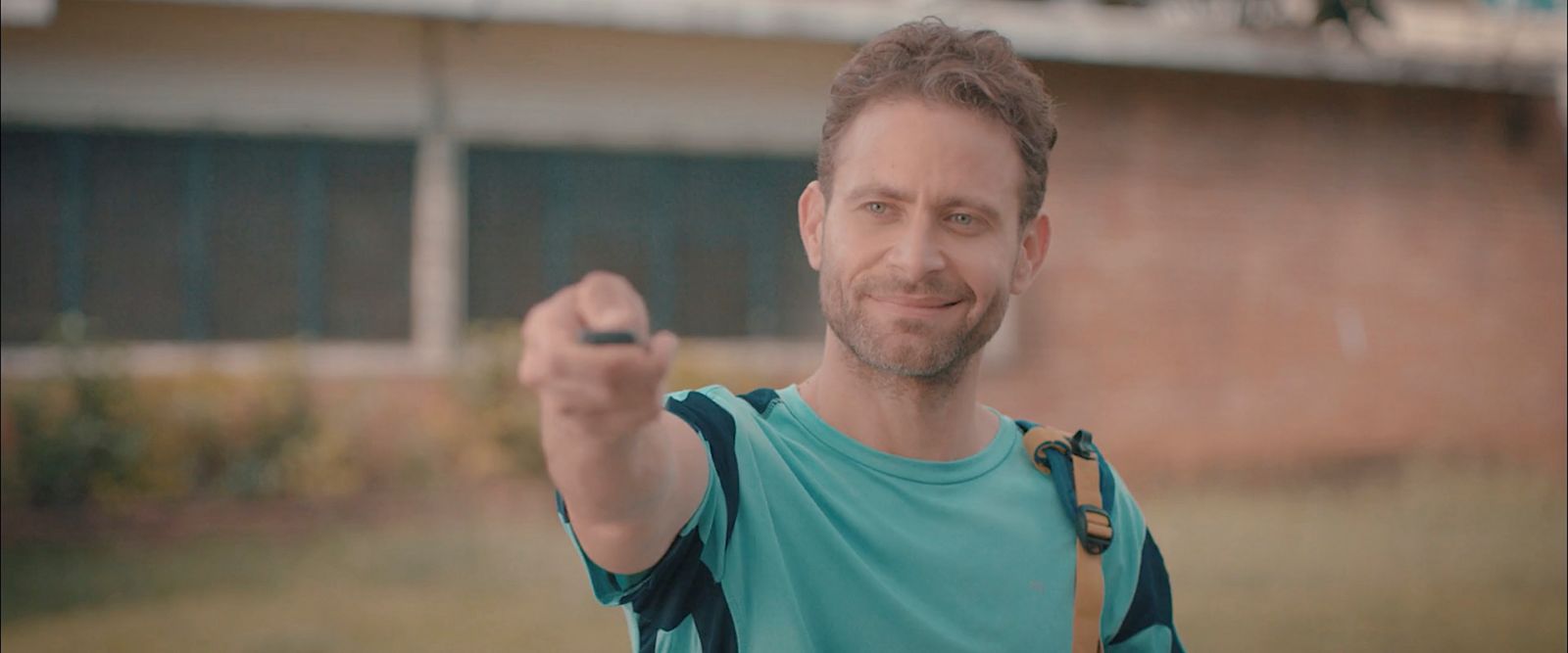 a man in a blue shirt holding a black object