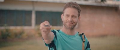 a man in a blue shirt holding a black object