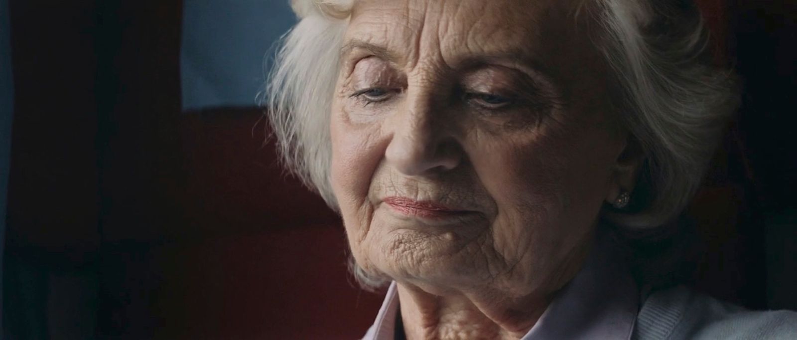 an elderly woman looking out a window