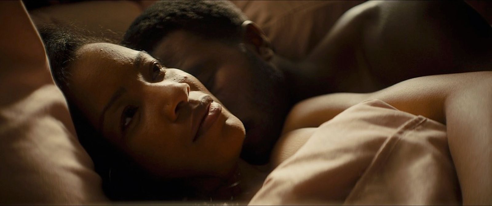 a man and a woman laying in bed together