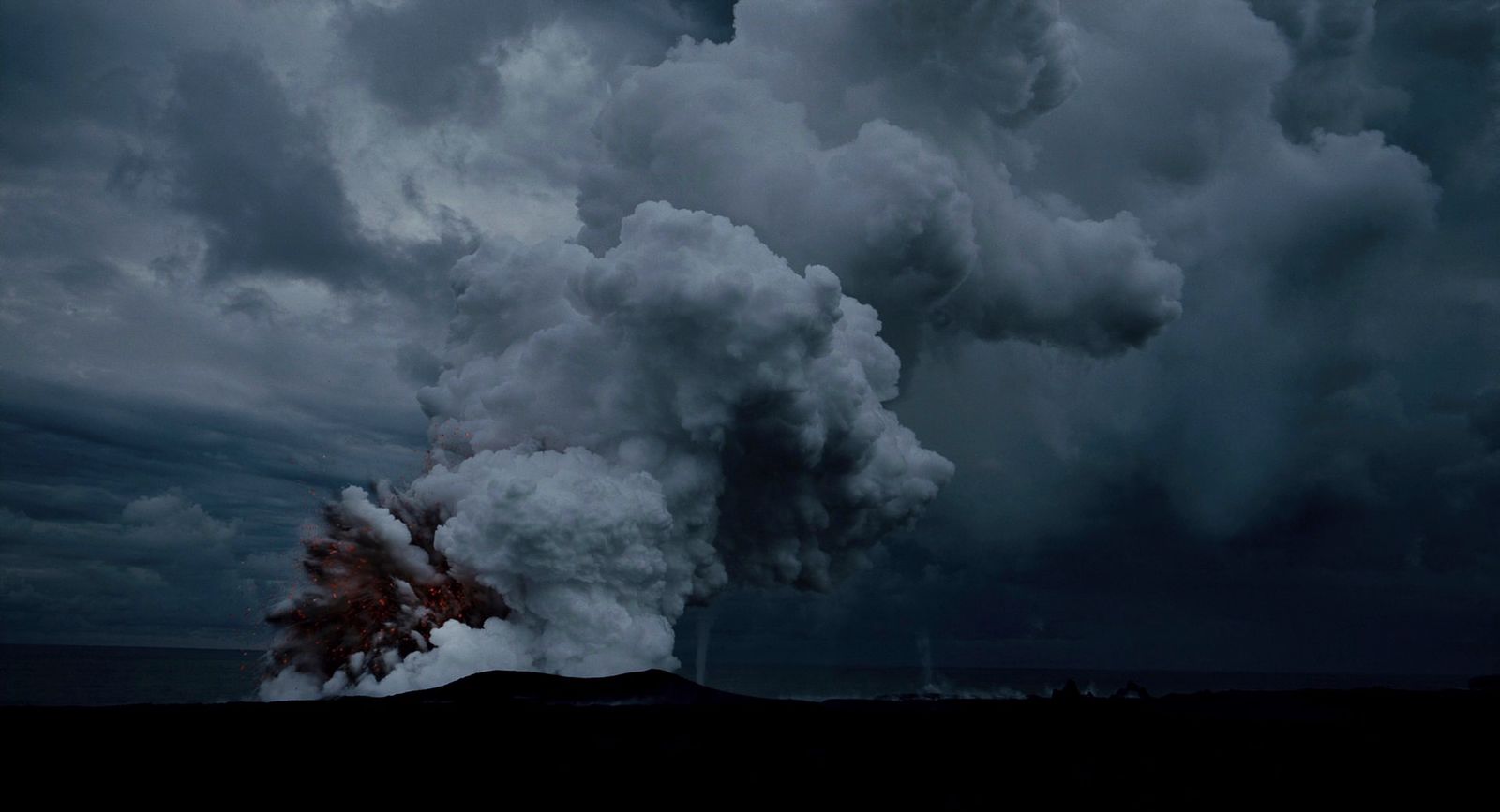 a large plume of smoke coming out of a volcano