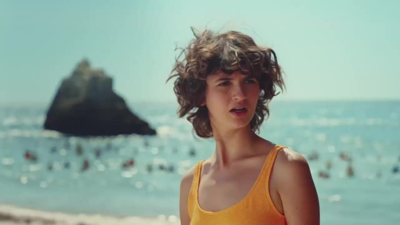 a woman standing on a beach next to the ocean