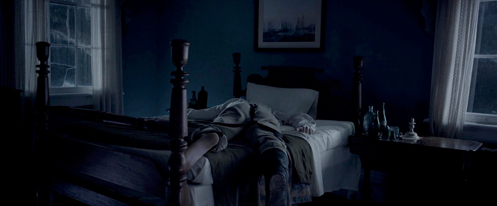 a person laying on a bed in a dark room