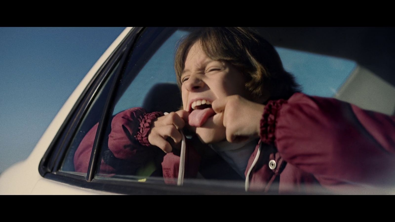 a woman sticking her tongue out of a car window