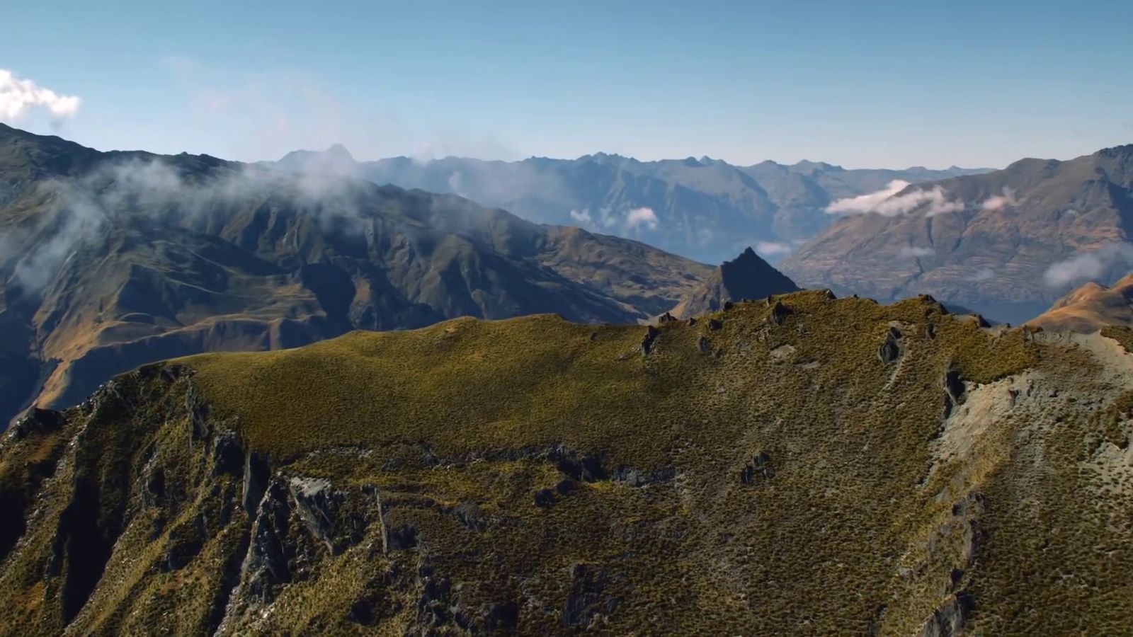 a view of a mountain range with clouds in the sky