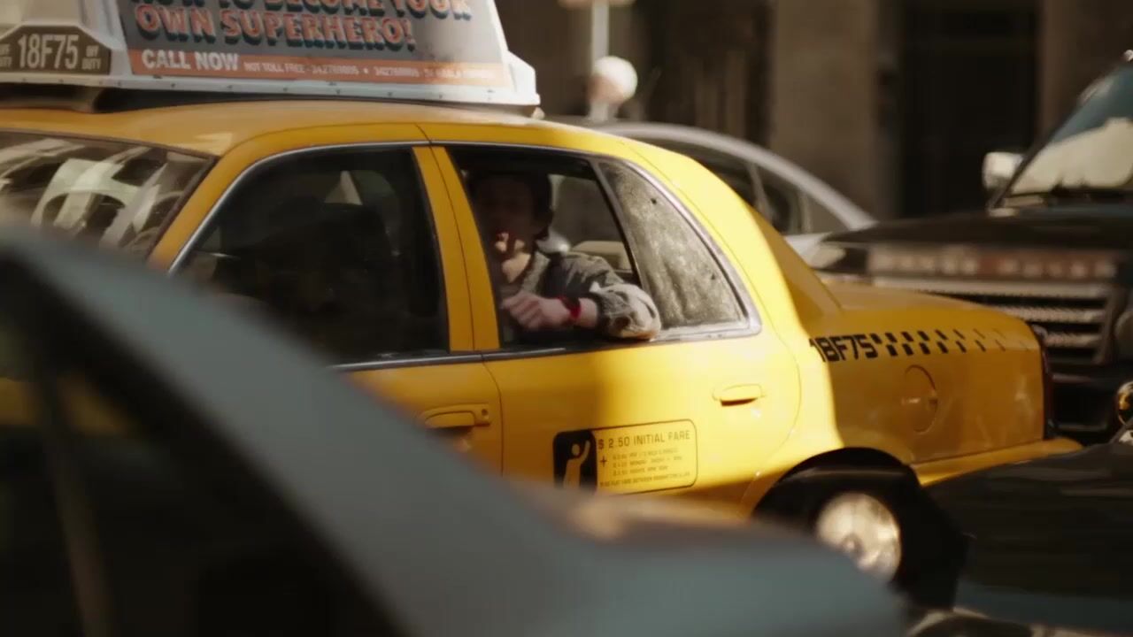 a taxi cab driving down a busy city street