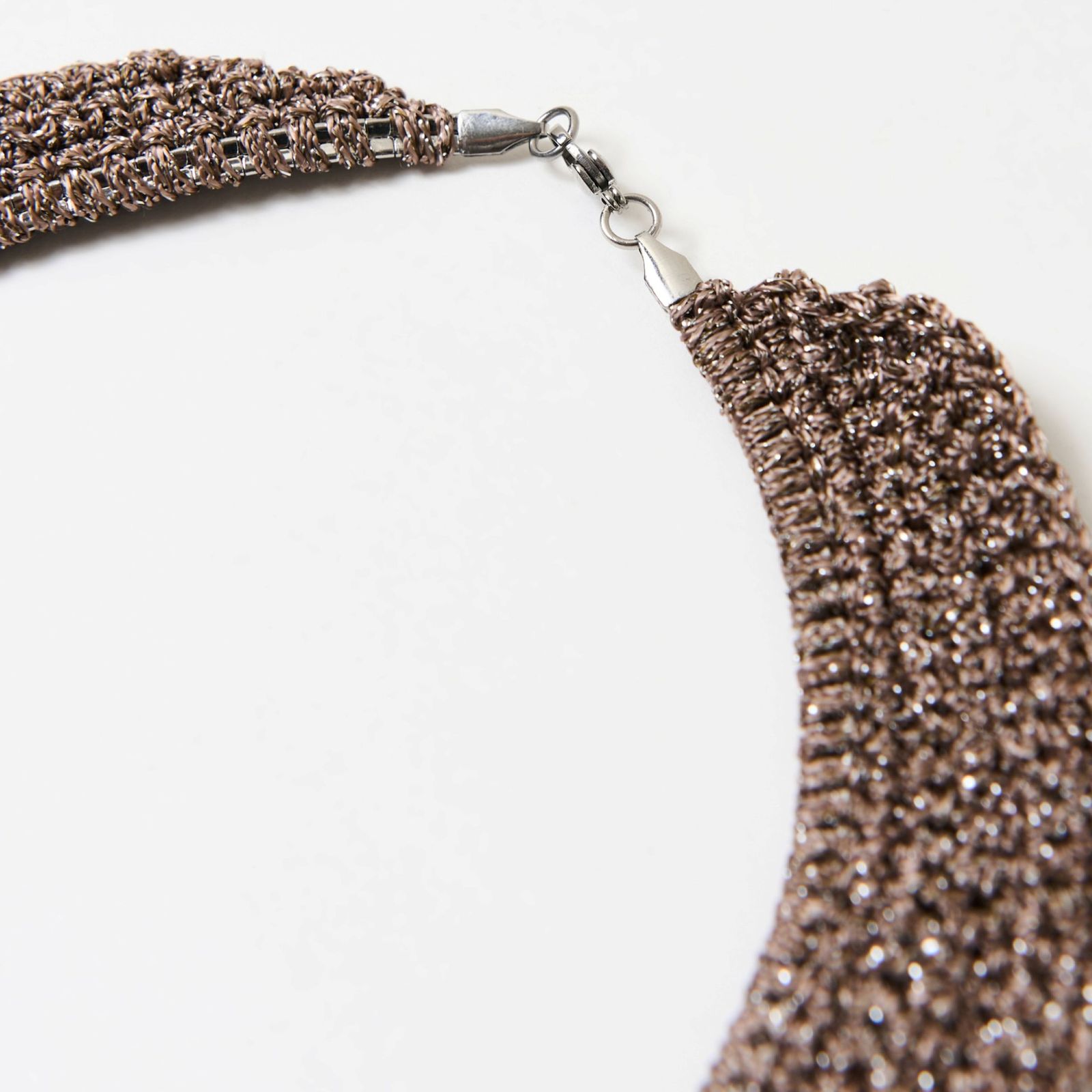 a close up of a necklace on a white surface
