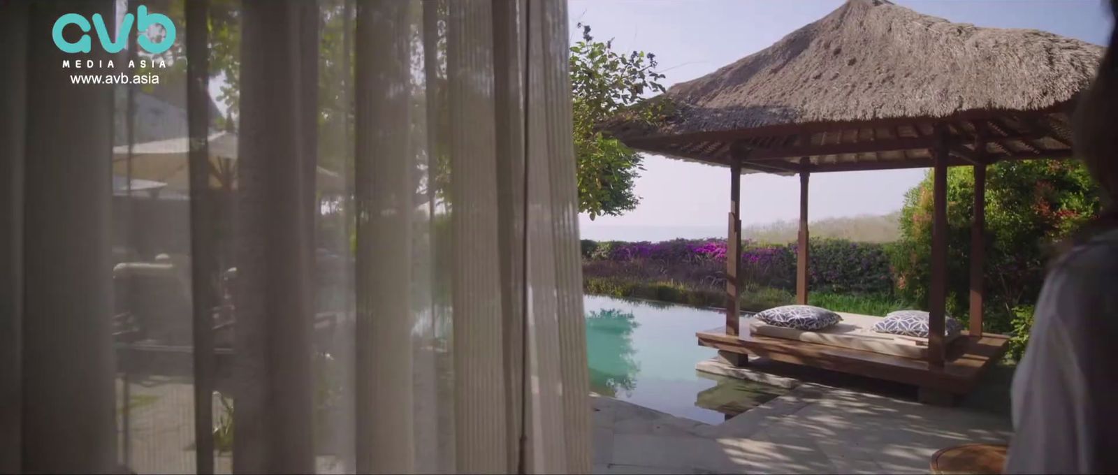 a woman standing in front of a gazebo next to a body of water