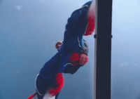 a man in a blue and red suit doing a handstand