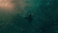 a man swimming in the ocean with a large amount of water around him