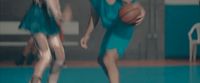 a woman in a blue dress holding a basketball