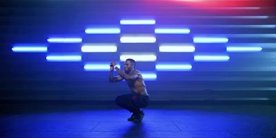 a shirtless man is dancing in a dark room