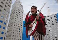 a person with a guitar in a city