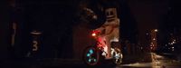 a man riding a bike down a street at night