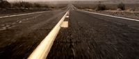 a car driving down an empty road in the desert