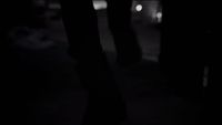 a black and white photo of a person's legs in the dark