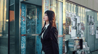 a woman in a suit standing in front of a building