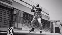 a black and white photo of a man on a skateboard