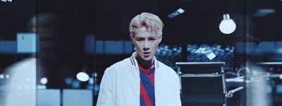 a man with blonde hair wearing a white jacket