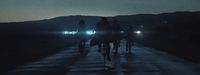 a group of people riding bikes down a road at night