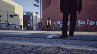 a man walking down a street next to a tall building