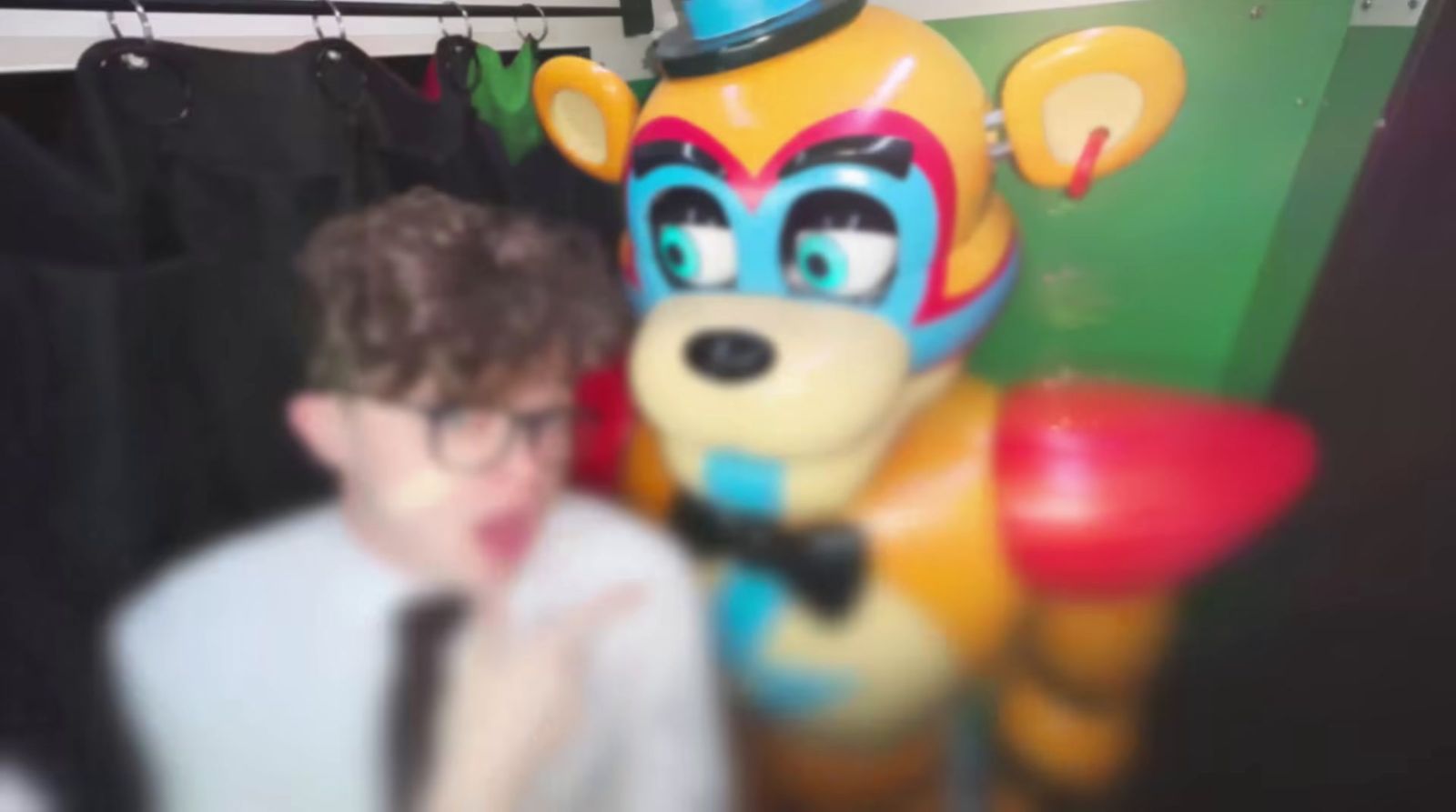 a young boy standing next to a large stuffed animal