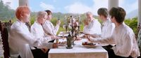 a group of people sitting around a table eating food