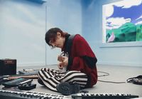 a woman sitting on the floor in front of a keyboard