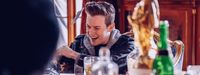 a man laughing while sitting at a table