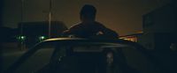 a man sitting on top of a car in the dark