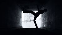 a person doing a handstand in a dark tunnel